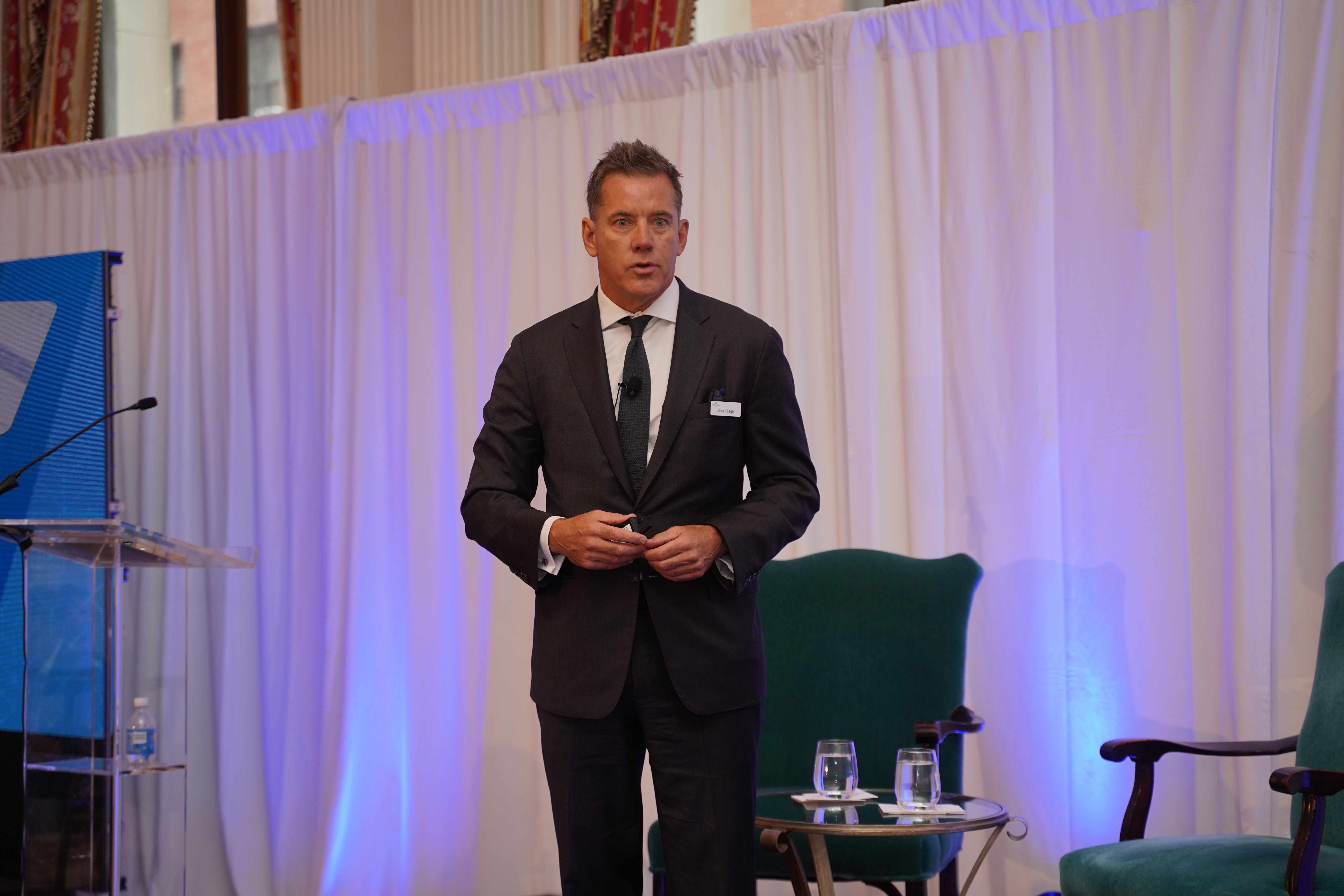 Daniel Leger standing to deliver a talk from the stage